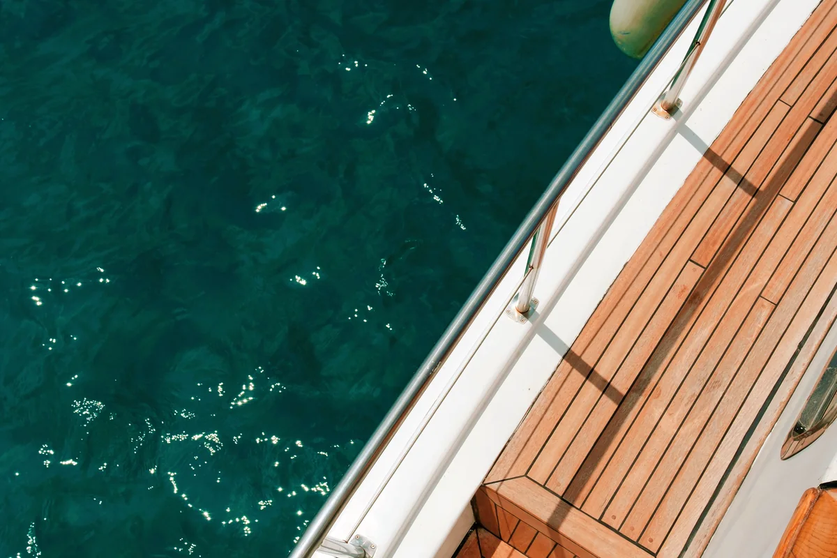 Side deck and steps beside clear blue water.